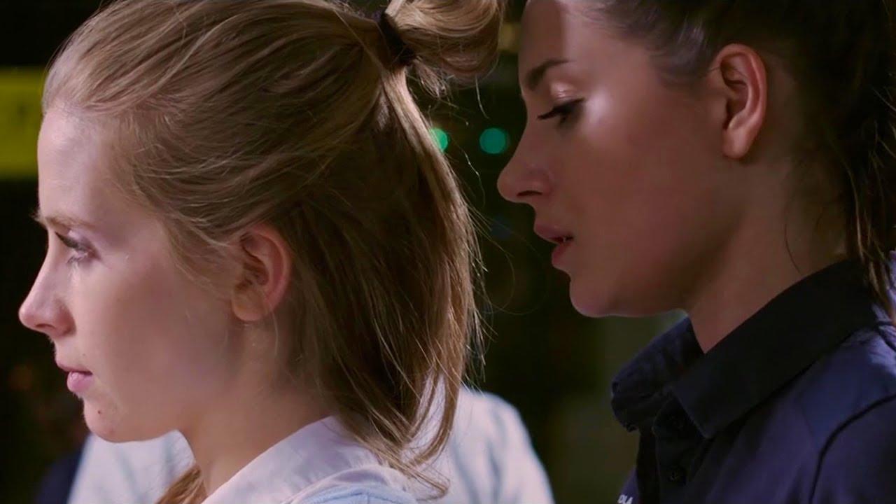 Extreme close up of two women, Natalia and Majka. Natalia is facing Majka; Majka is giving her back to Natalia.